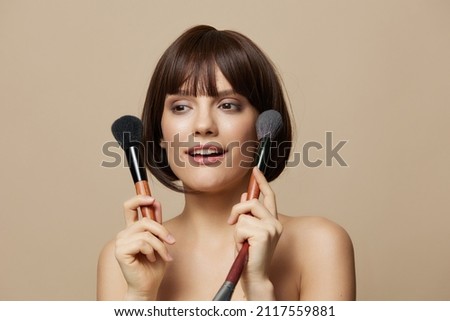 woman makeup brushes near the face bare shoulders close-up Lifestyle