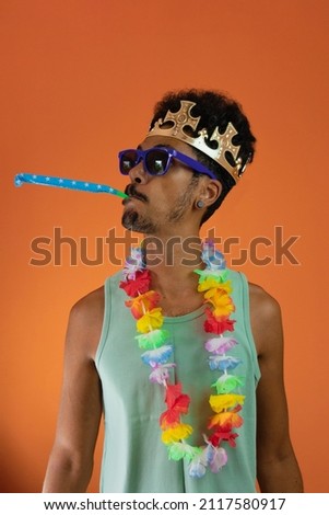 Black man in costume for carnival with pandemic mask isolated on orange background.  Royalty-Free Stock Photo #2117580917