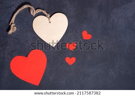 Red heart and wood heart, dark textured background