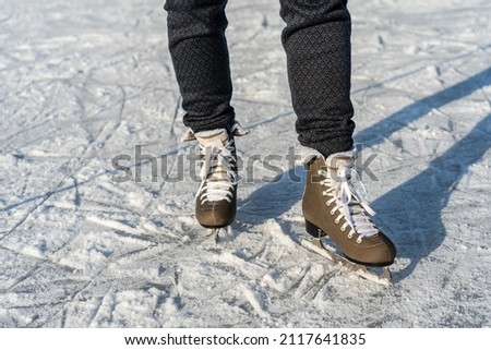 Women's figure skates on ice with a little bit snow