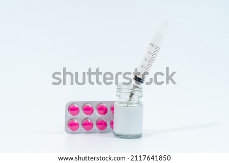 Medical glass bottle with syringe and tablets (pills) isolated on white background