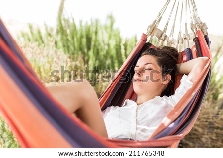 Young beautiful woman sleeping on hammock in the very hot summer day on the beach or desert. Moment from the vocation. Tired from the trip. Royalty-Free Stock Photo #211765348