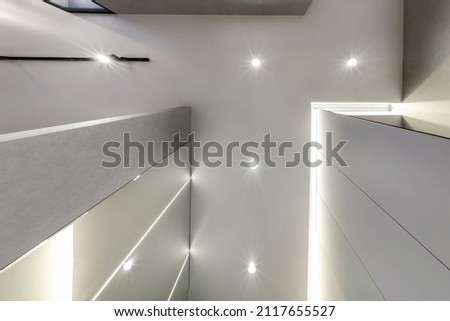 suspended ceiling with halogen spots lamps and drywall construction in empty room in apartment or house. Stretch ceiling white and complex shape. Royalty-Free Stock Photo #2117655527