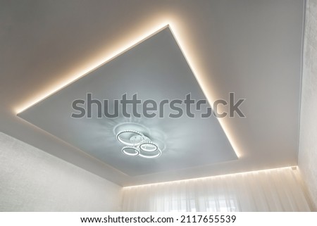 suspended ceiling with halogen spots lamps and drywall construction in empty room in apartment or house. Stretch ceiling white and complex shape. Royalty-Free Stock Photo #2117655539