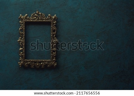 Vintage openwork bronze metal frame on a old wall background Royalty-Free Stock Photo #2117656556
