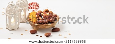 Ramadan Kareem and iftar muslim food, holiday concept. Trays with nuts and dried fruits and latterns with candles. Celebration idea Royalty-Free Stock Photo #2117659958