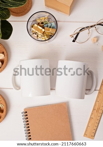 Modern eco friendly desktop with zero waste stationary and white mug mockup. Comfortable working space, sustainable life style concept. Top view, flat lay.