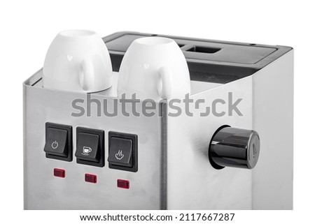 ceramic white espresso cups stand on top of a professional warming coffee machine, a steel coffee maker and black home appliance control buttons close-up of an object isolated on a white background.