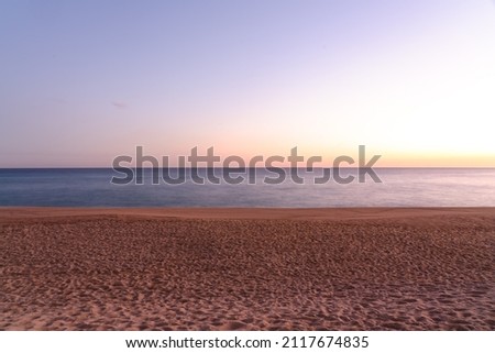 long exposure shot of sandy beach at sunset, empty beach  Royalty-Free Stock Photo #2117674835