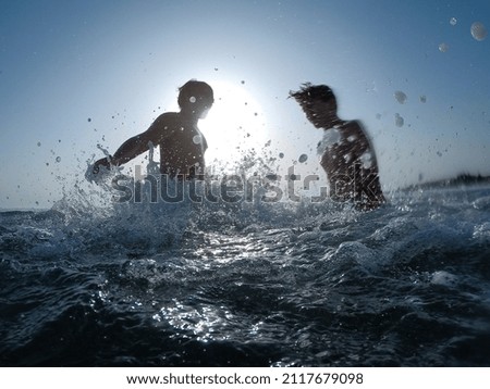 Boys playing in the water with splashes