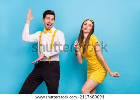 Portrait of two positive satisfied partners have fun discotheque fifties isolated on blue color background