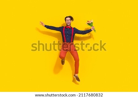 Full length photo of young man energetic jumper hurry hold flowers husband romance isolated over yellow color background