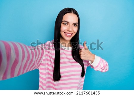 Photo of young cheerful girl shooting video record show thumb up feedback great isolated over blue color background