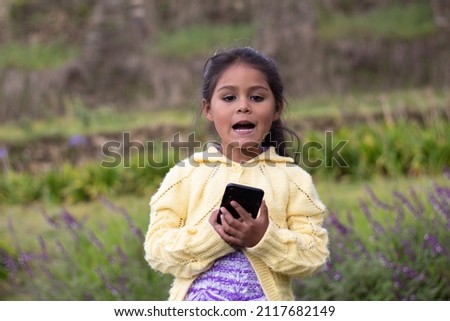 
happy girl holding a cell phone in her hand, nature,
