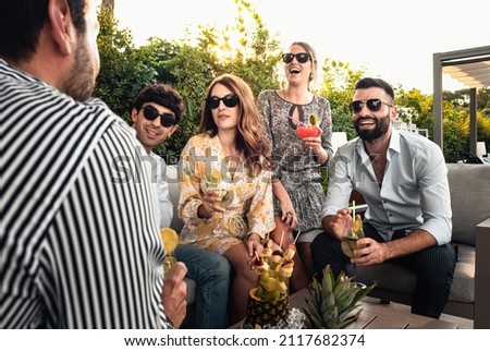 hangout with friends sitting in the terrace garden who talk and drink with fruit mocktails and chatting together carefree - upbeat youth celebrating birthday in the patio - guests get-together 