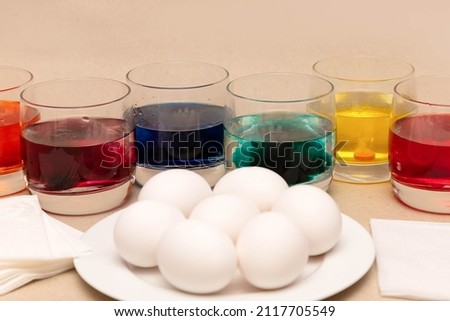 Coloring eggs for Easter at home. Photo instruction. White eggs, napkins, food coloring water in glasses. Step 3.