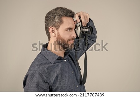 Unshaven photojournalist in casual style shirt take photograph with handheld photo camera, paparazzi