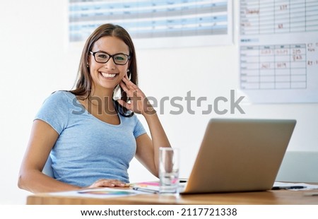 She's an inspired designer. Portrait of a female designer working on her laptop at her office desk.