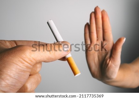 Woman showing stop sign with hand and refusing to take cigarette. No smoking or quit smoking concept Royalty-Free Stock Photo #2117735369