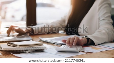 Close up Businessman using calculator and laptop for calaulating finance, tax, accounting, statistics and analytic research concept
