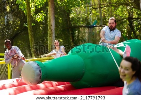 Funny attraction with a huge inflatable bottle in an amusement park. High quality photo
