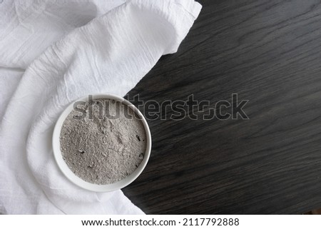 White bowl of ashes and white linen on dark wood with copy space Royalty-Free Stock Photo #2117792888