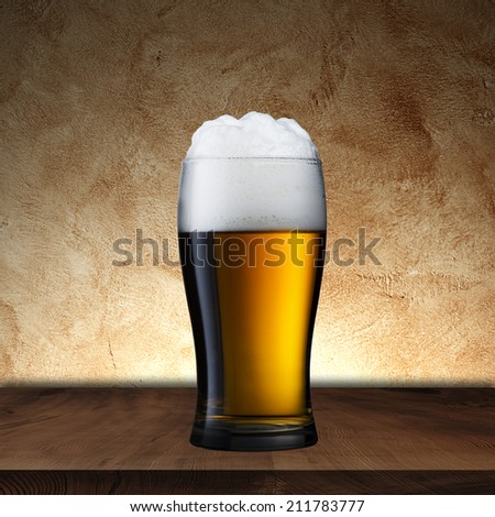 Glass of beer on wood table with grunge background
