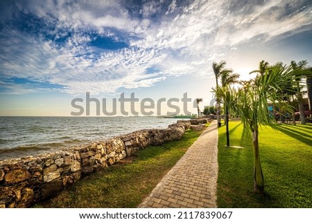 View of the walkway in a park on the shore of Lake Victoria in Entebbe, Uganda, during the last rays of sunlight in the evening Royalty-Free Stock Photo #2117839067