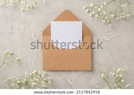 Top view photo of woman's day composition open craft paper envelope with paper card and white gypsophila flowers on isolated textured grey concrete background with empty space Royalty-Free Stock Photo #2117842958