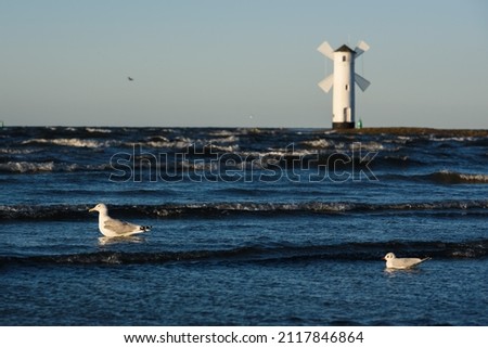 Seascape with lighthouse looks like windmill. Swinoujcie in Poland.