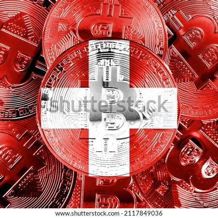 Holds a physical version of Bitcoin and the Swiss flag. Conceptual image of Swiss cryptocurrency and blockchain technology. Double exposure creative bitcoin symbol hologram. 
