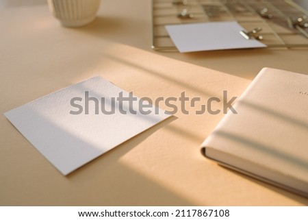 Paper mock up, daily planner on beige office desk with beautiful sunlight. Minimal aesthetic business brand, blog, social media template background.