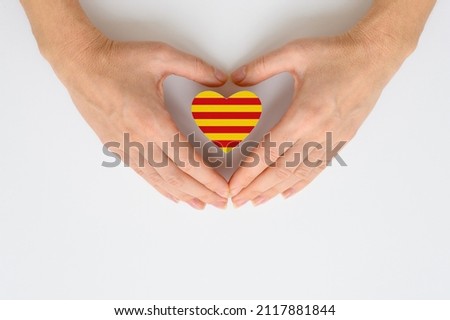 The national flag of Catalonia in female hands.
