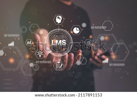 Close up of businessman hand holding to LMS - Learning Management System web icon for lesson and online education, course, application, study, e learning, knowledge everywhere and every time.