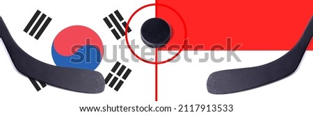 Top view hockey puck with South Korea vs. Indonesia command with the sticks on the flag. Concept hockey competitions