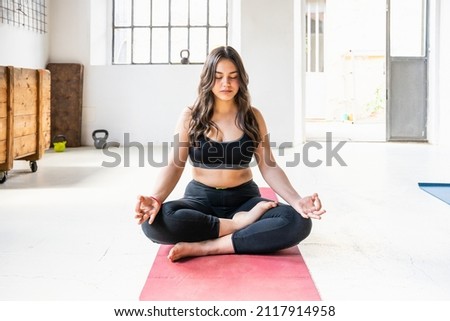 Beginner young beautiful young woman with sporty clothes does yoga exercises in the gym on the mat - Millennials trains with work out fitness for health - Concept of mental and physical well-being Royalty-Free Stock Photo #2117914958