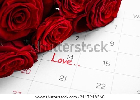 Calendar with word LOVE and roses, closeup. Valentine's Day celebration