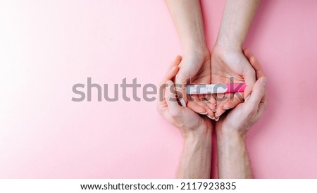 Pregnancy test kit. Female hand hold positive pregnant test with silk ribbon on pink banner background. Medical healthcare gynecological, pregnancy fertility maternity people concept Royalty-Free Stock Photo #2117923835