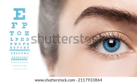Ophthalmology - Closeup of female eye with blue iris and chart for visual acuity test Royalty-Free Stock Photo #2117933864