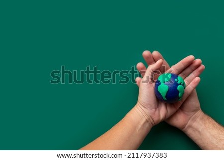 Hands of man and woman holding the Earth, caring for the planet, environment, ecology, humanity, with copy space