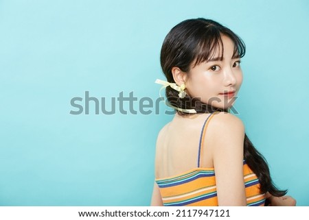 Fresh portrait of young Asian woman on blue background