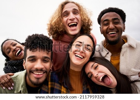 Selfie of Group of young cheerful people looking at the camera outdoors. Happy smiling friends hugging. Concept of community and youth lifestyle