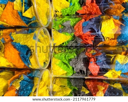 Multicolored chips. Chips with dye. Sale of chips of different colors. Potato chips. Junk food.  
