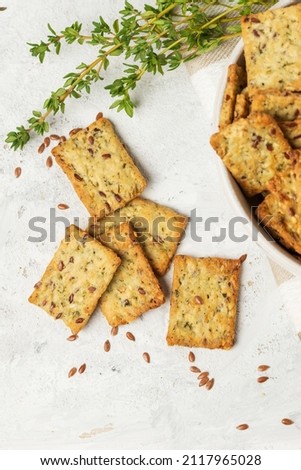 Homemade diet cookies with herbs, flaxseed and spices  on  light table. Herbal crunchy crackers with green thyme, top view Royalty-Free Stock Photo #2117965028