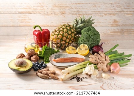 Healthy food assortment as an anti-inflammatory diet with vegetables, nuts, fruits, spices and fish on a light wooden background, high angle view from above, copy space Royalty-Free Stock Photo #2117967464