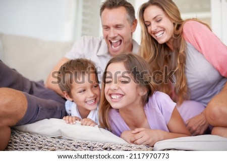 Attack of the tickle monsters. Shot of a happy young family playing together.