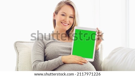 Display your pregnancy information here. Shot of a pregnant woman holding up a tablet at home.