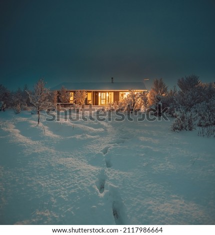 Northern Lights and Aurora Borealis over Winter landscape with wooden house under a beautiful starry sky and in Iceland. Royalty-Free Stock Photo #2117986664