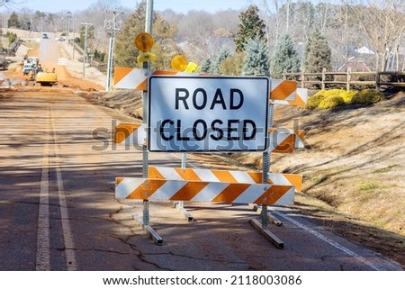 Road closed ahead sign and caution cones on the street barricades