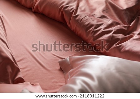 Closeup view of bed with beautiful silk linens Royalty-Free Stock Photo #2118011222